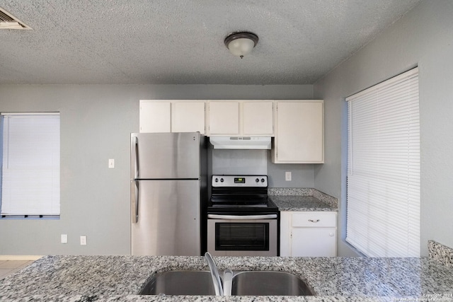 kitchen with white cabinetry, sink, light stone countertops, and appliances with stainless steel finishes