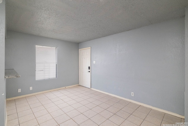 tiled spare room with a textured ceiling