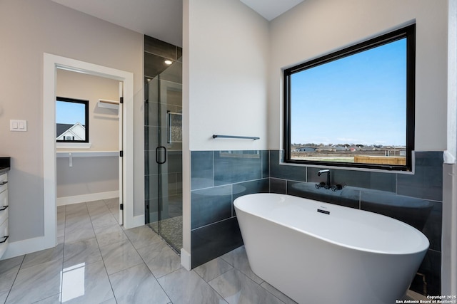 bathroom with shower with separate bathtub, vanity, and tile walls