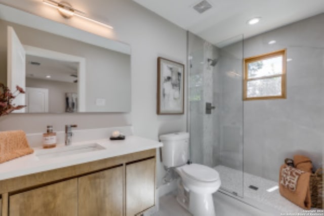 bathroom featuring an enclosed shower, vanity, and toilet