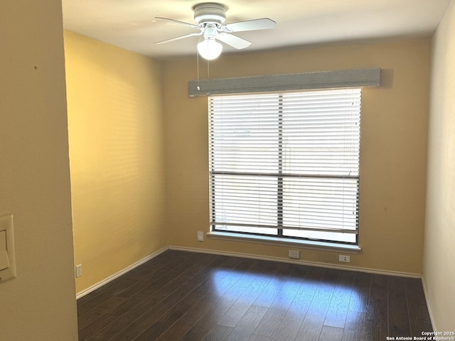 unfurnished room with dark wood-style floors, ceiling fan, and baseboards