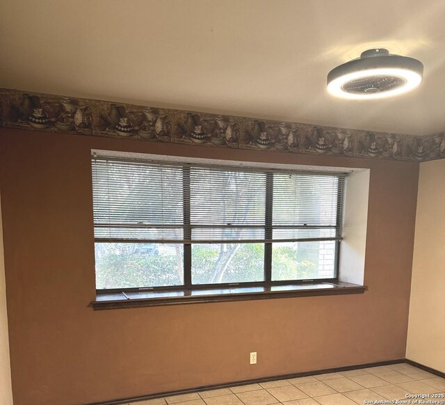 spare room featuring baseboards and light tile patterned floors