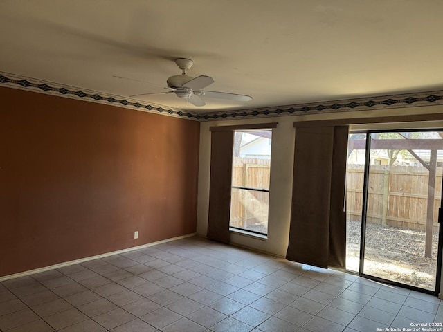 empty room with ceiling fan, baseboards, and light tile patterned floors