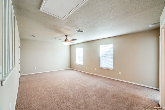 unfurnished room featuring light carpet, a textured ceiling, and ceiling fan