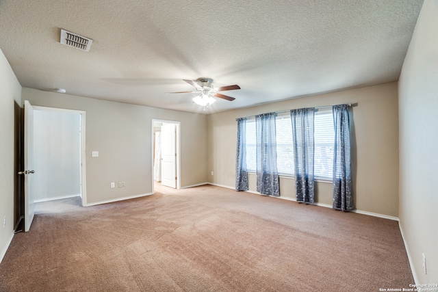 carpeted spare room with a textured ceiling and ceiling fan