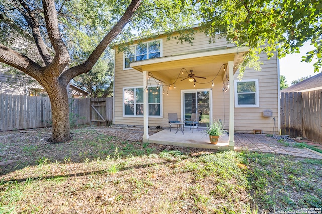 rear view of property featuring ceiling fan and a patio area