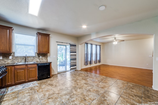 kitchen featuring dishwasher, sink, decorative backsplash, ceiling fan, and light hardwood / wood-style floors