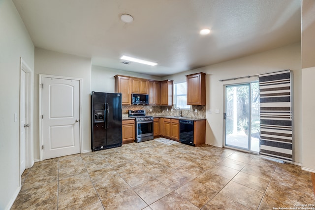 kitchen with light tile patterned floors, sink, tasteful backsplash, and black appliances