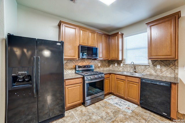 kitchen featuring backsplash, stone counters, black appliances, sink, and light tile patterned floors