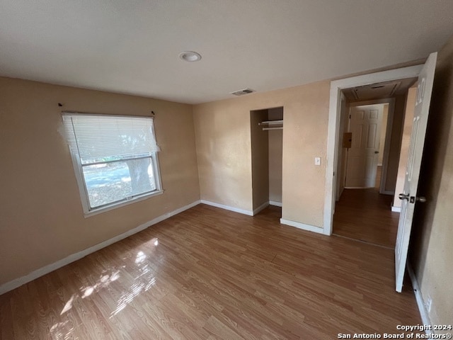 unfurnished bedroom featuring hardwood / wood-style flooring and a closet