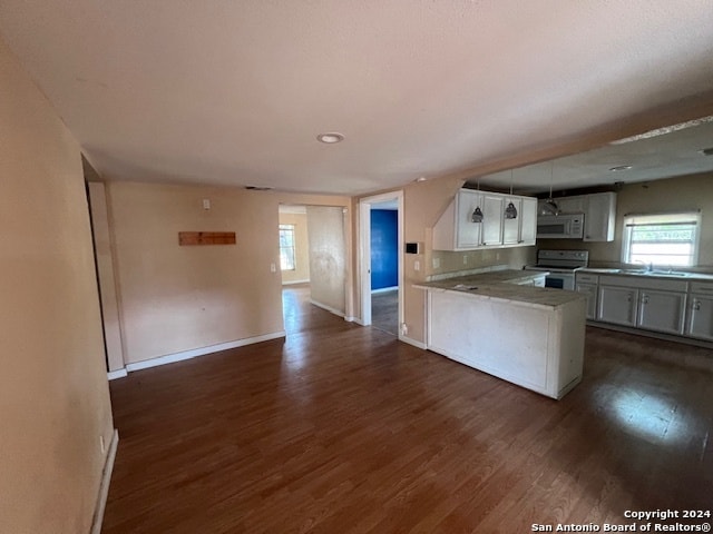 kitchen featuring kitchen peninsula, white appliances, dark hardwood / wood-style floors, and white cabinetry