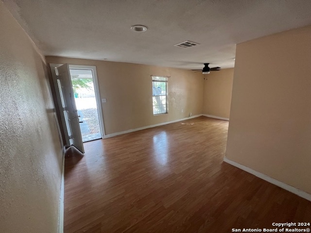 empty room featuring ceiling fan and dark wood-type flooring