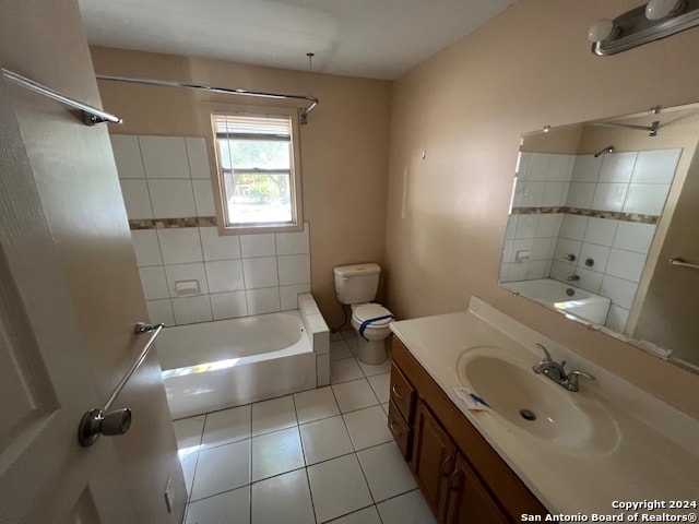 full bathroom featuring tile patterned floors, vanity, tiled shower / bath combo, and toilet