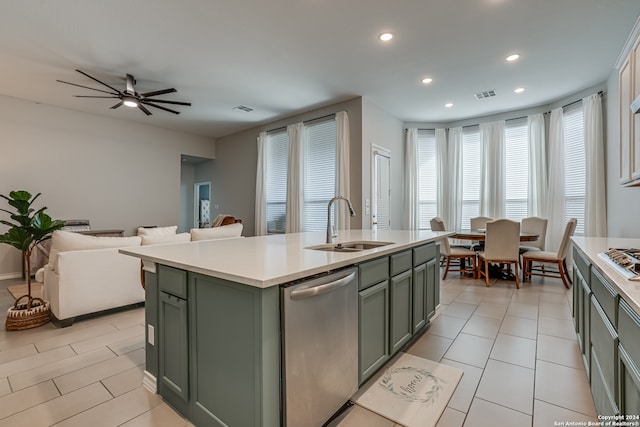 kitchen with appliances with stainless steel finishes, ceiling fan, a kitchen island with sink, sink, and green cabinets