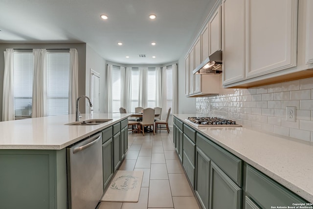 12303 Tower Frst, San Antonio, TX 78253 - kitchen with stainless steel appliances, under cabinet range hood, green cabinets, light tile patterned floors, and decorative backsplash