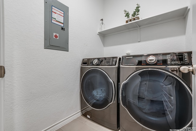 laundry area with electric panel, light tile patterned flooring, and washer and dryer