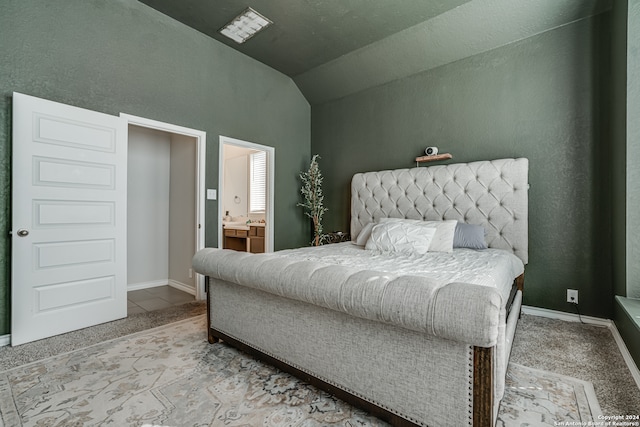 carpeted bedroom featuring connected bathroom and lofted ceiling