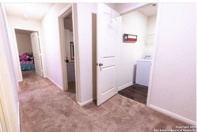 hall featuring washer / clothes dryer and light carpet