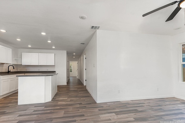 kitchen with hardwood / wood-style floors, white cabinetry, and sink