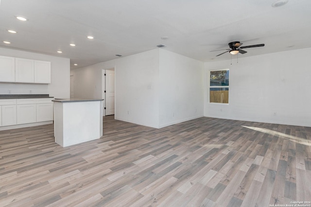 unfurnished living room featuring light hardwood / wood-style flooring and ceiling fan