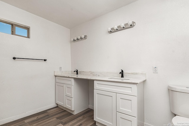 bathroom with wood-type flooring, vanity, and toilet