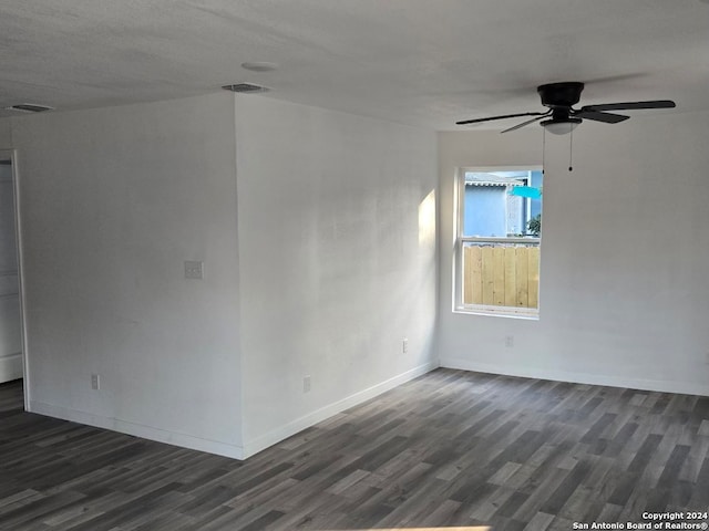 empty room with ceiling fan and dark wood-type flooring