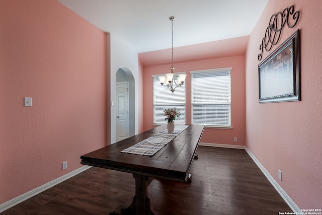 dining room with dark hardwood / wood-style flooring and a notable chandelier