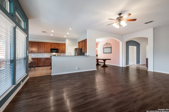 unfurnished living room featuring dark hardwood / wood-style flooring and ceiling fan