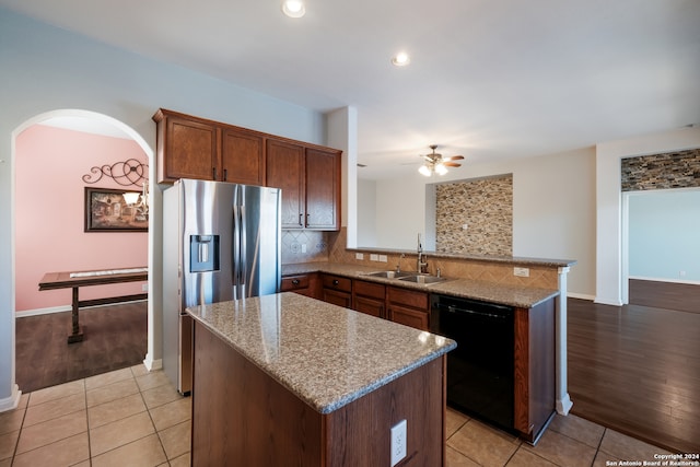 kitchen featuring kitchen peninsula, stainless steel refrigerator with ice dispenser, light wood-type flooring, sink, and dishwasher