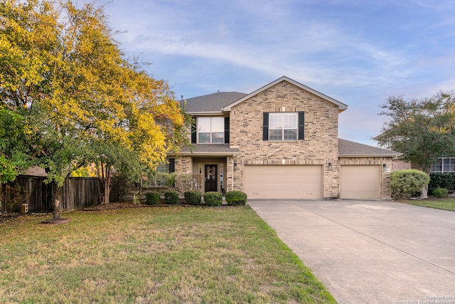 view of property with a garage and a front lawn