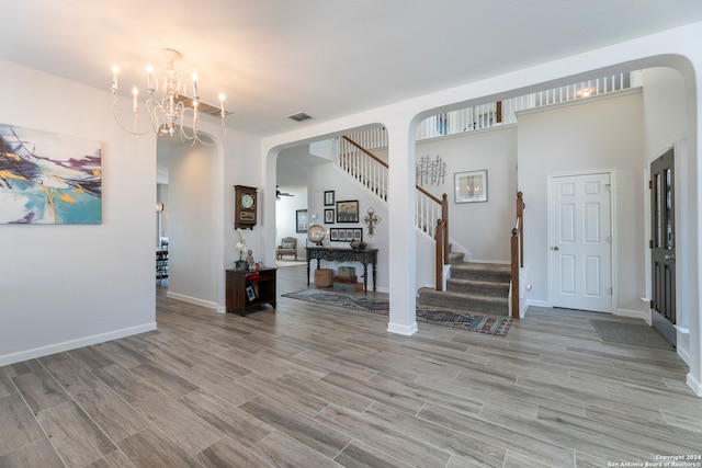 entrance foyer with a notable chandelier and light hardwood / wood-style flooring