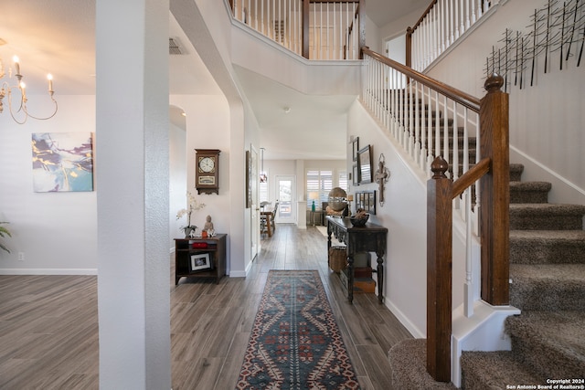 foyer featuring hardwood / wood-style floors, a high ceiling, and a chandelier