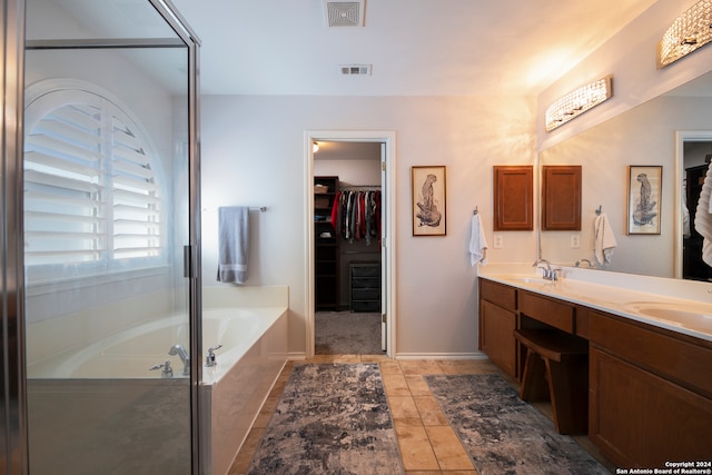 bathroom with tile patterned flooring, vanity, and plus walk in shower