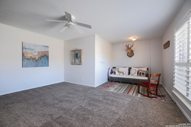 sitting room with dark carpet and ceiling fan