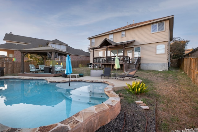 view of pool featuring outdoor lounge area, a gazebo, a patio area, and a wooden deck