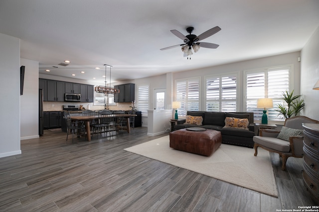 living room featuring ceiling fan, a healthy amount of sunlight, and dark wood-type flooring