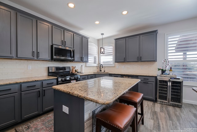 kitchen with plenty of natural light, a kitchen island, pendant lighting, and appliances with stainless steel finishes