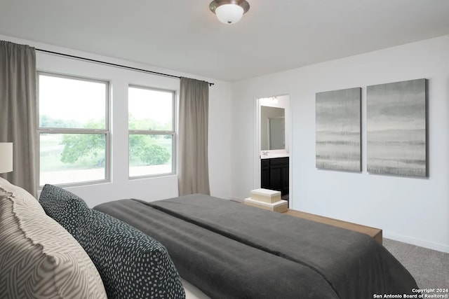 bedroom featuring connected bathroom and carpet floors