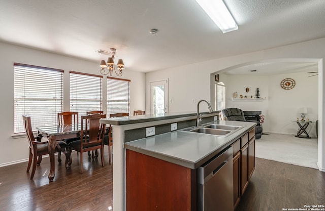 kitchen with a center island with sink, sink, stainless steel dishwasher, dark hardwood / wood-style floors, and a chandelier