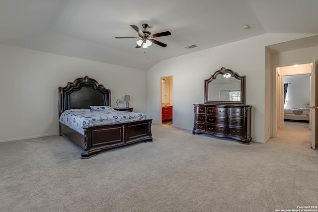 bedroom with ceiling fan, ensuite bathroom, vaulted ceiling, and light carpet