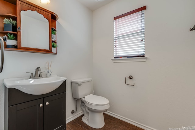 bathroom with hardwood / wood-style floors, vanity, and toilet