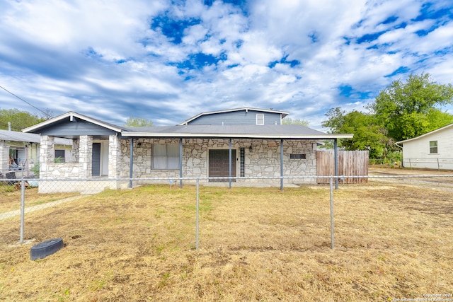 back of house with covered porch and a lawn