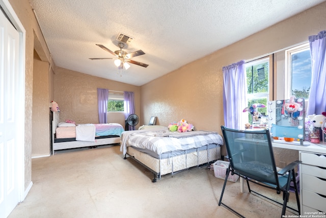 bedroom with ceiling fan, a textured ceiling, and vaulted ceiling