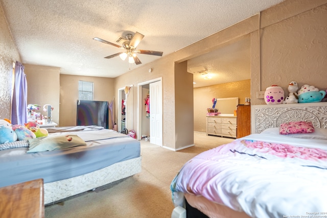 bedroom with ceiling fan, light colored carpet, and a textured ceiling