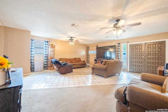 tiled living room featuring a textured ceiling and ceiling fan