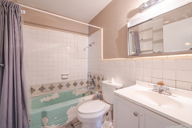 full bathroom with shower / tub combo, vanity, toilet, and tile walls