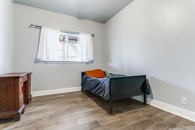 bedroom with wood finished floors and baseboards