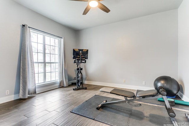 exercise room featuring ceiling fan, baseboards, and wood finished floors