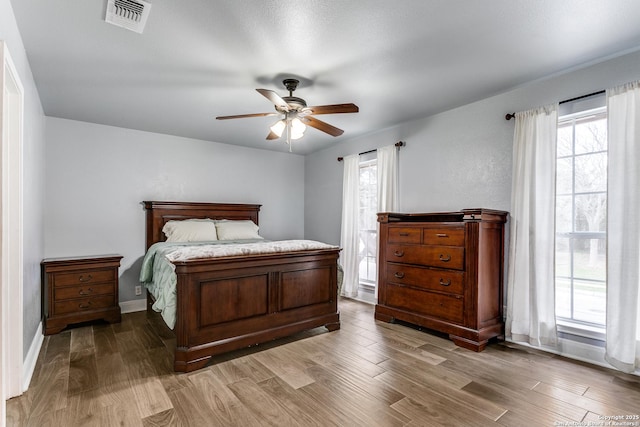 bedroom with light wood finished floors, multiple windows, and visible vents