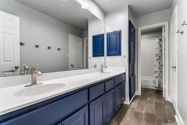 full bathroom with a sink, double vanity, shower / bath combo, and wood finished floors